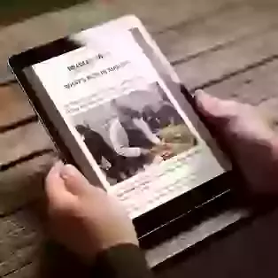 Article on Tablet PC held by man